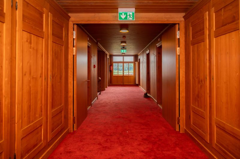 Sanierung des denkmalgeschützten Hotel Kreuz in Romoos – Nachher | 2. OG | Korridor Hotelzimmer | -	Neu mit Brandschutztür | Wände mit Erhalt historischen Oberflächen